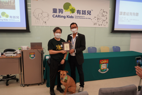 Dr Paul Wong, associate professor, Department of Social Work and Social Administration, HKU presents a certificate to Taxi Wong and his handler Ms. Rebecca Ngan